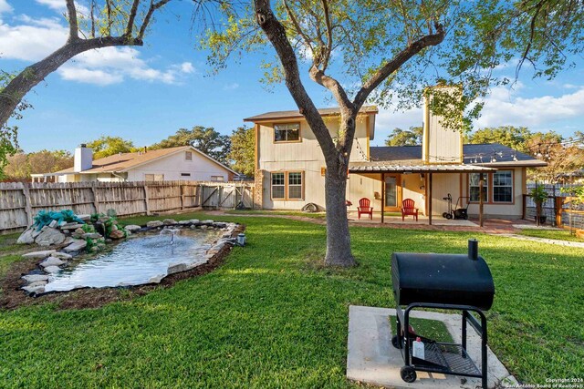 rear view of house featuring a patio area and a lawn