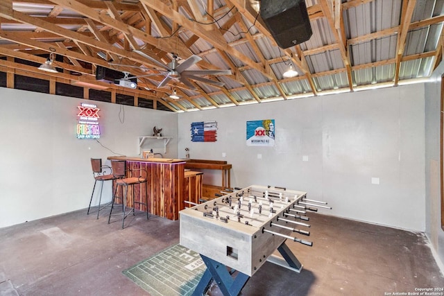 game room with high vaulted ceiling and concrete floors