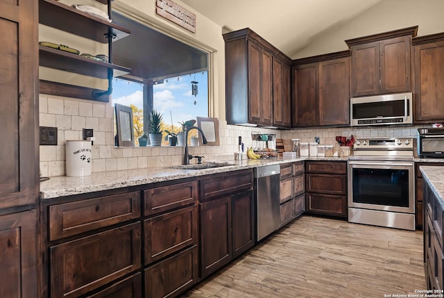 kitchen with sink, decorative backsplash, dark brown cabinets, light hardwood / wood-style floors, and stainless steel appliances