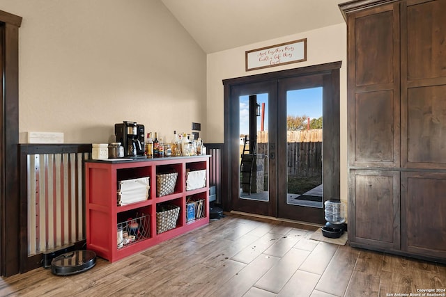 entryway with wood-type flooring, lofted ceiling, and french doors