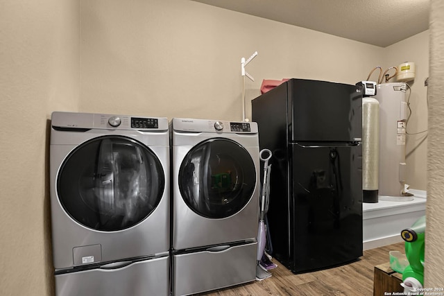 laundry area with washing machine and dryer, wood-type flooring, and a textured ceiling