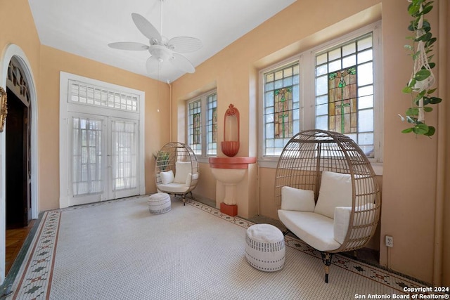 living area featuring ceiling fan and french doors