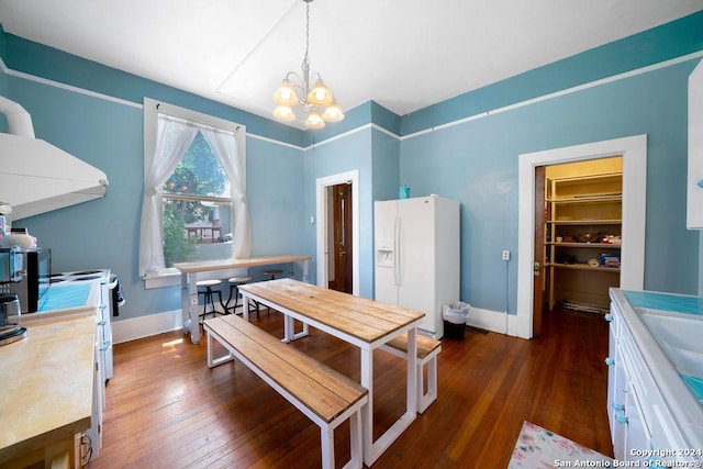 dining room with dark wood-type flooring and an inviting chandelier