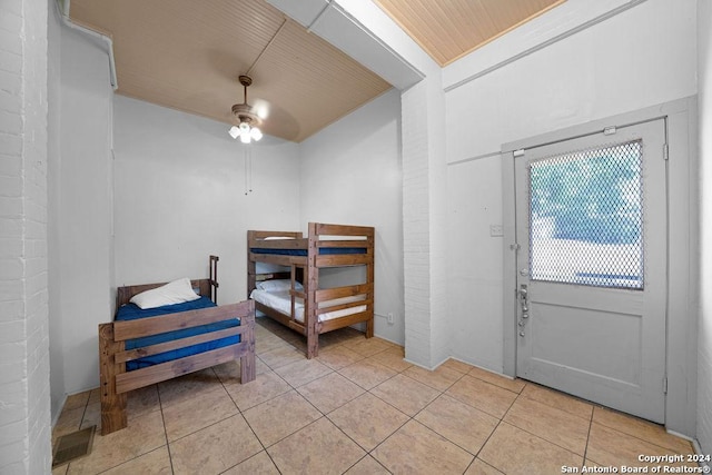 foyer with ceiling fan, light tile patterned floors, and wooden ceiling