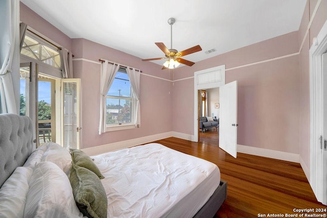 bedroom with access to exterior, dark hardwood / wood-style floors, and ceiling fan