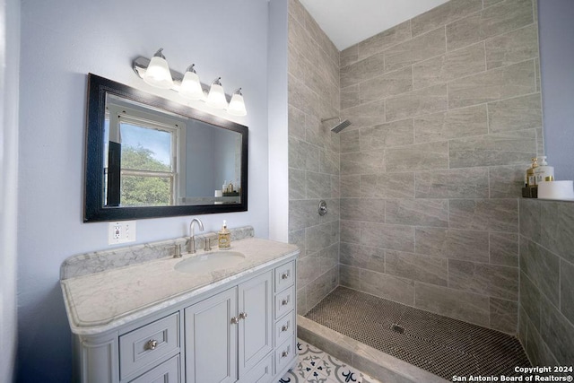 bathroom featuring a tile shower, tile patterned flooring, and vanity