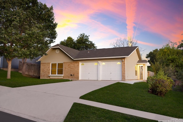 ranch-style home with a garage and a yard