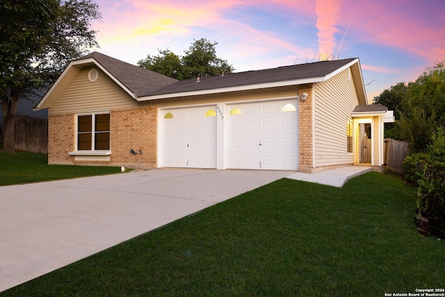 single story home featuring a yard and a garage