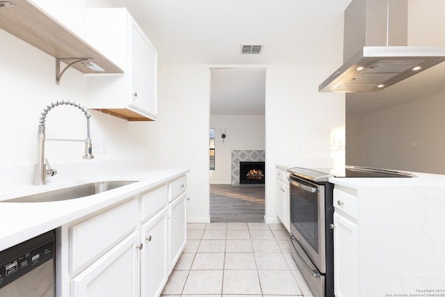 kitchen featuring island exhaust hood, sink, white cabinets, and appliances with stainless steel finishes