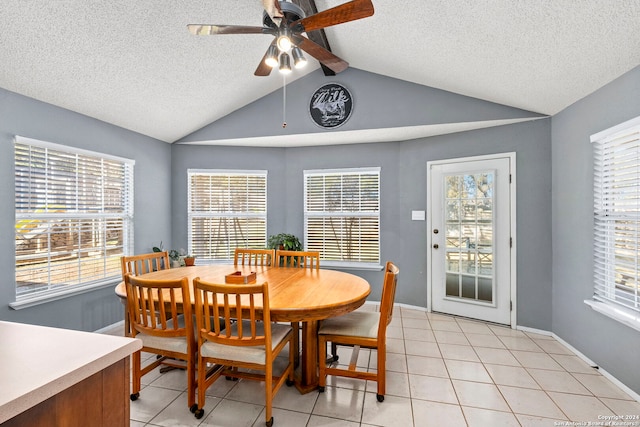 tiled dining space with a textured ceiling, lofted ceiling with beams, and ceiling fan