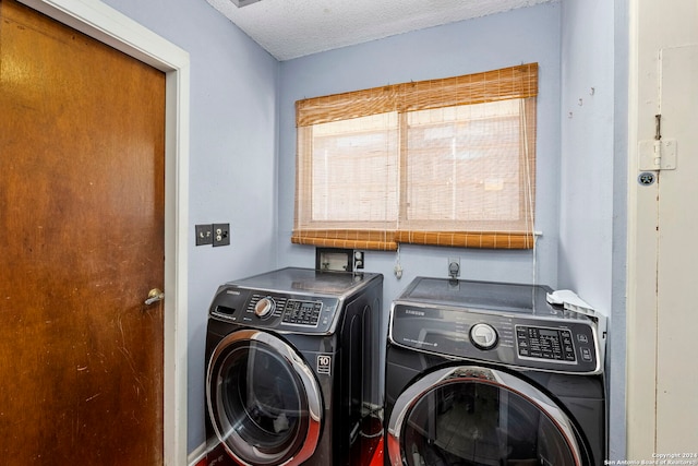 laundry area featuring washer and clothes dryer and a textured ceiling