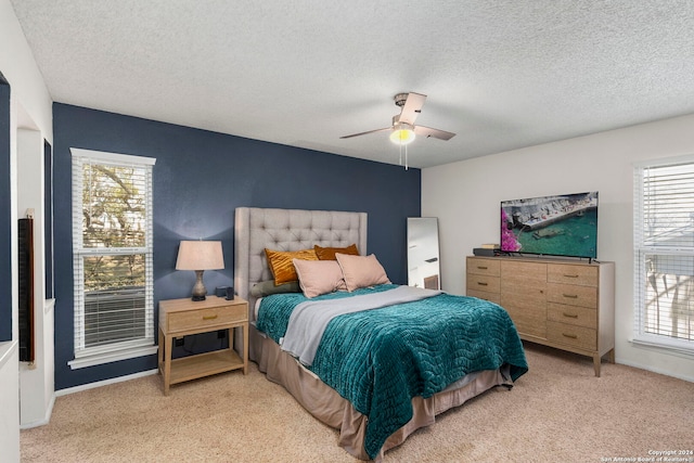 bedroom featuring multiple windows, ceiling fan, and light carpet