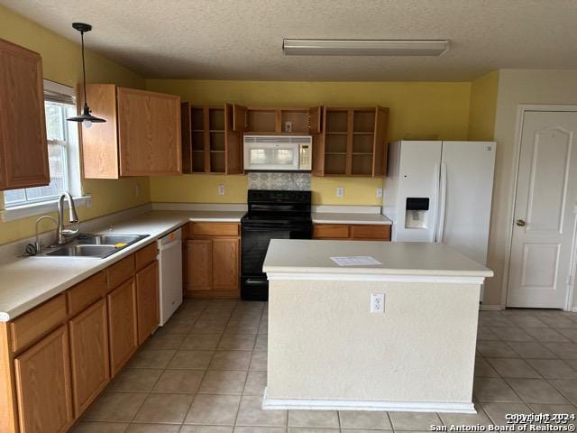 kitchen with white appliances, sink, hanging light fixtures, a textured ceiling, and a kitchen island