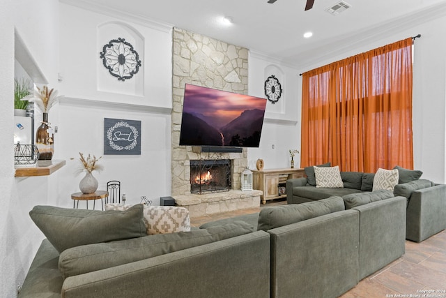 living room featuring ceiling fan, crown molding, and a fireplace