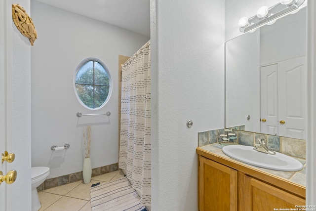 bathroom with tile patterned floors, vanity, toilet, and walk in shower