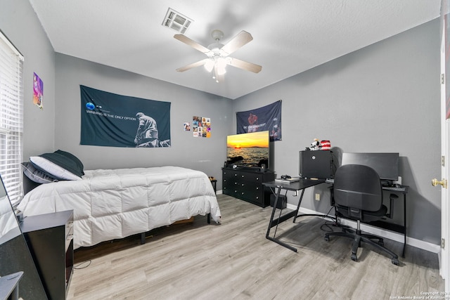 bedroom with light hardwood / wood-style floors and ceiling fan