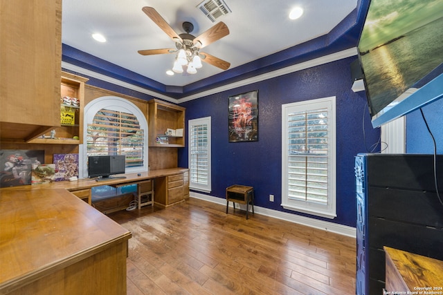 office featuring hardwood / wood-style flooring, a raised ceiling, plenty of natural light, and crown molding