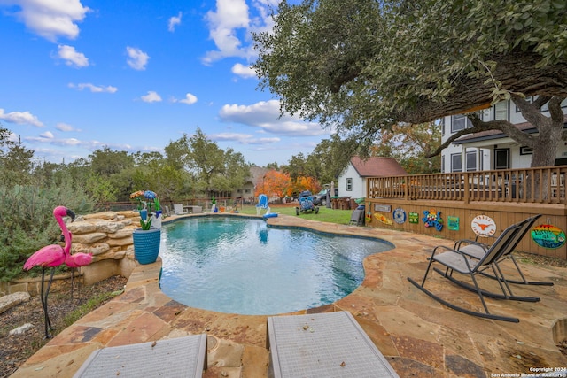 view of swimming pool featuring a patio area and a wooden deck