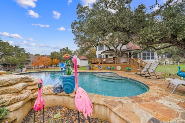 view of pool featuring a patio and a wooden deck