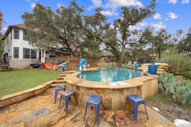 view of pool featuring a yard and a wooden deck