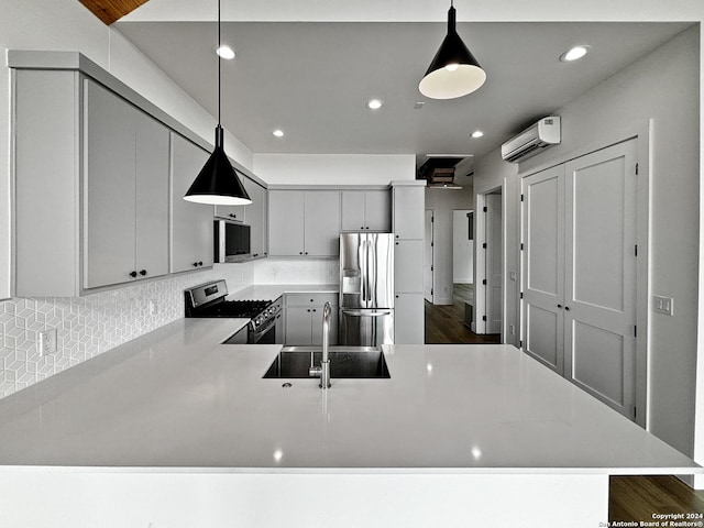 kitchen featuring sink, stainless steel appliances, dark hardwood / wood-style flooring, kitchen peninsula, and decorative light fixtures