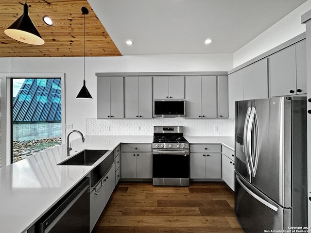 kitchen featuring dark hardwood / wood-style flooring, gray cabinetry, stainless steel appliances, sink, and decorative light fixtures