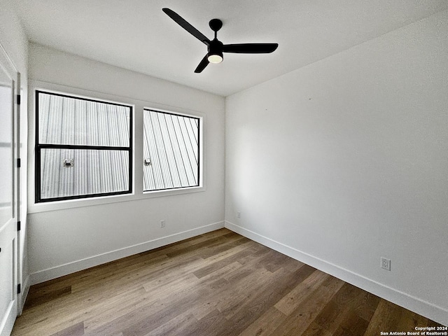 empty room with hardwood / wood-style floors and ceiling fan