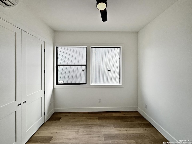 unfurnished bedroom featuring ceiling fan, a closet, and light hardwood / wood-style flooring