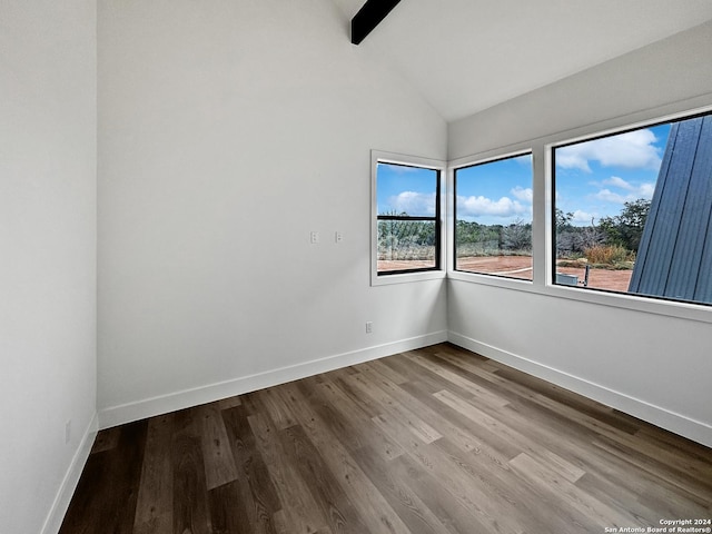 spare room featuring hardwood / wood-style flooring and lofted ceiling