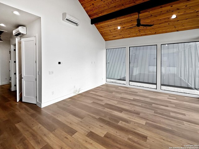 empty room featuring hardwood / wood-style floors, wooden ceiling, ceiling fan, beamed ceiling, and a wall unit AC