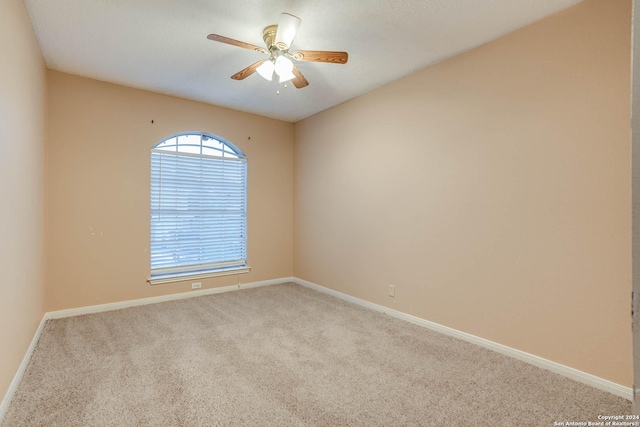 carpeted spare room with ceiling fan