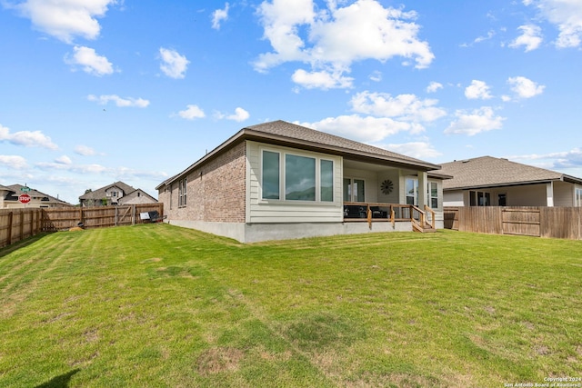 rear view of property featuring a yard