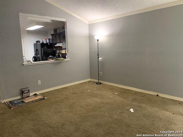 carpeted empty room featuring crown molding, vaulted ceiling, and a textured ceiling