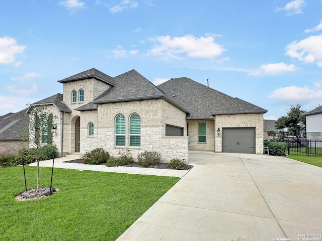 french country style house with a garage and a front lawn