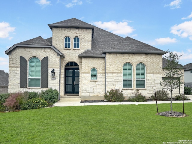 french country inspired facade with french doors and a front yard