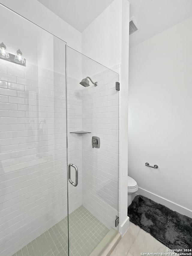 bathroom with tile patterned flooring, toilet, and walk in shower