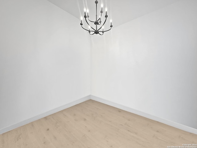 unfurnished dining area featuring light hardwood / wood-style flooring and a notable chandelier