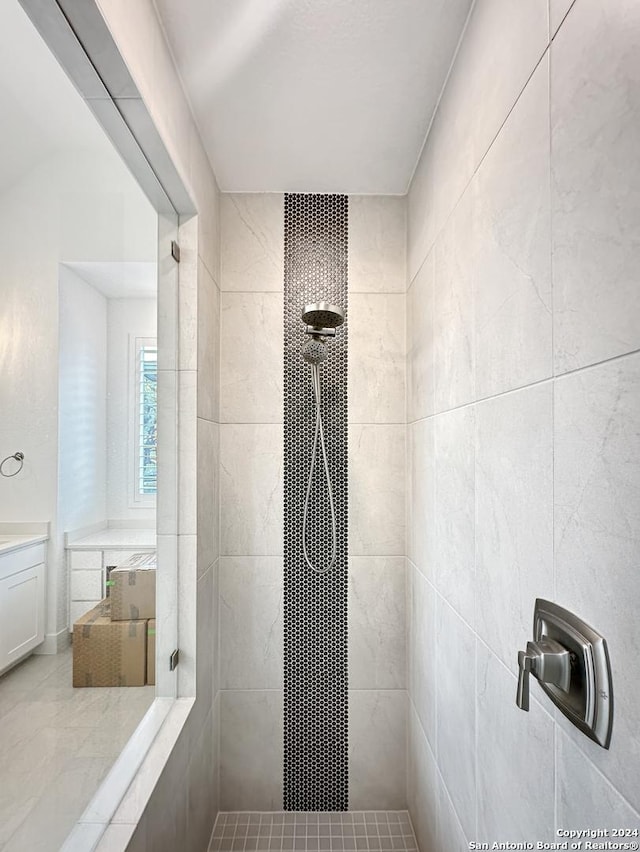 bathroom featuring tile patterned flooring and tiled shower