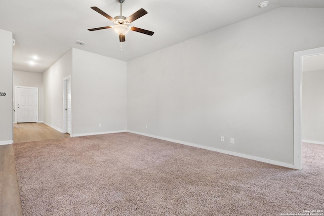 carpeted empty room with ceiling fan and lofted ceiling