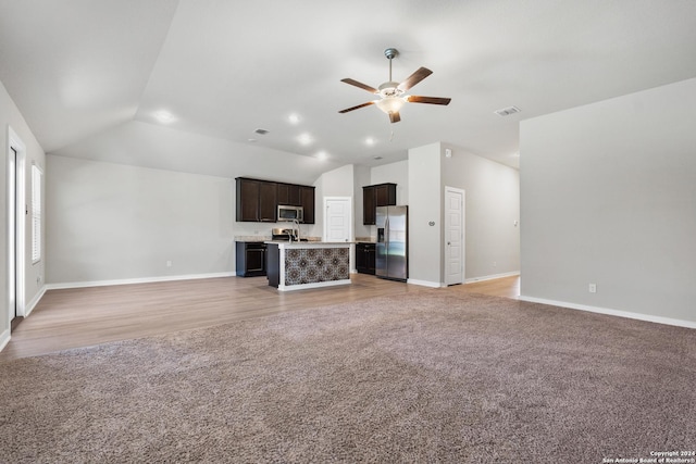 unfurnished living room featuring ceiling fan, light wood-type flooring, and vaulted ceiling