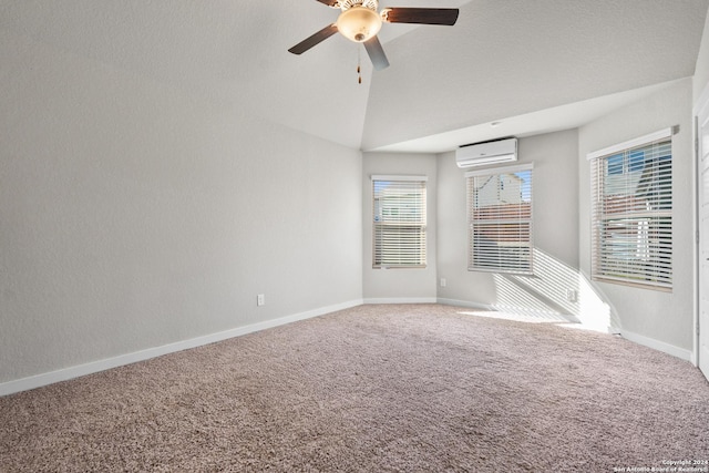 empty room featuring carpet flooring, high vaulted ceiling, a wall mounted AC, and ceiling fan