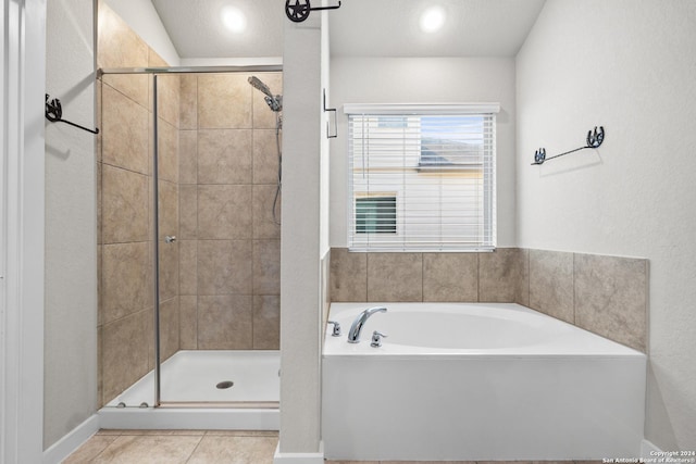 bathroom with tile patterned floors, plus walk in shower, and a textured ceiling