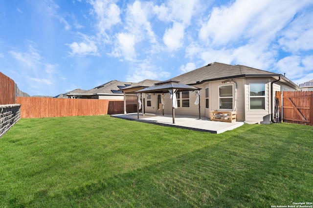 back of property featuring a gazebo, a patio area, and a lawn