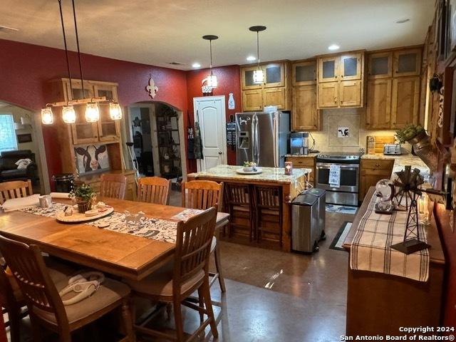 kitchen featuring backsplash, pendant lighting, a center island, and stainless steel appliances