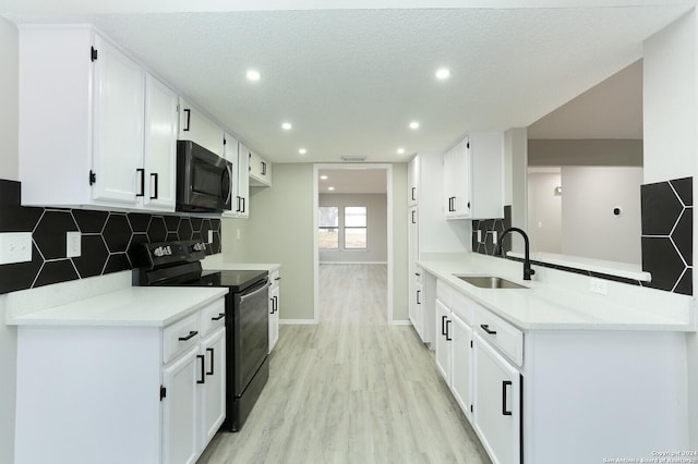 kitchen featuring sink, light hardwood / wood-style flooring, a textured ceiling, black / electric stove, and white cabinetry