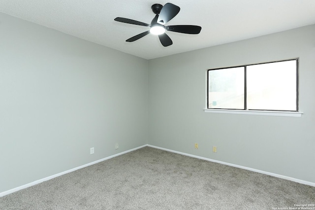 spare room featuring ceiling fan and light carpet