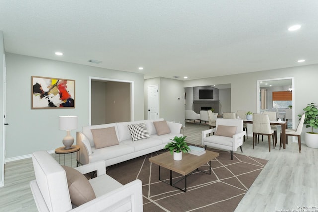 living room featuring a large fireplace, hardwood / wood-style floors, and a textured ceiling