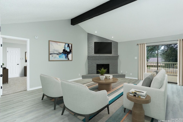 living room with lofted ceiling with beams, light hardwood / wood-style floors, and a brick fireplace