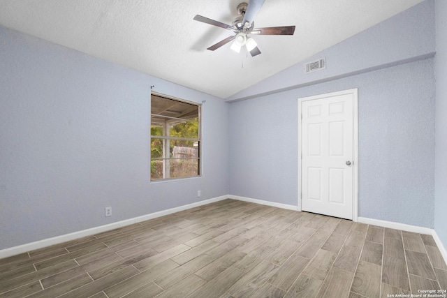 spare room featuring hardwood / wood-style flooring, ceiling fan, and vaulted ceiling