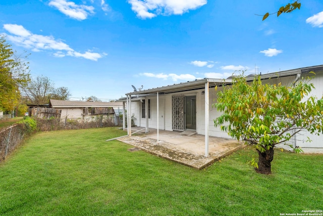 rear view of house featuring a yard and a patio